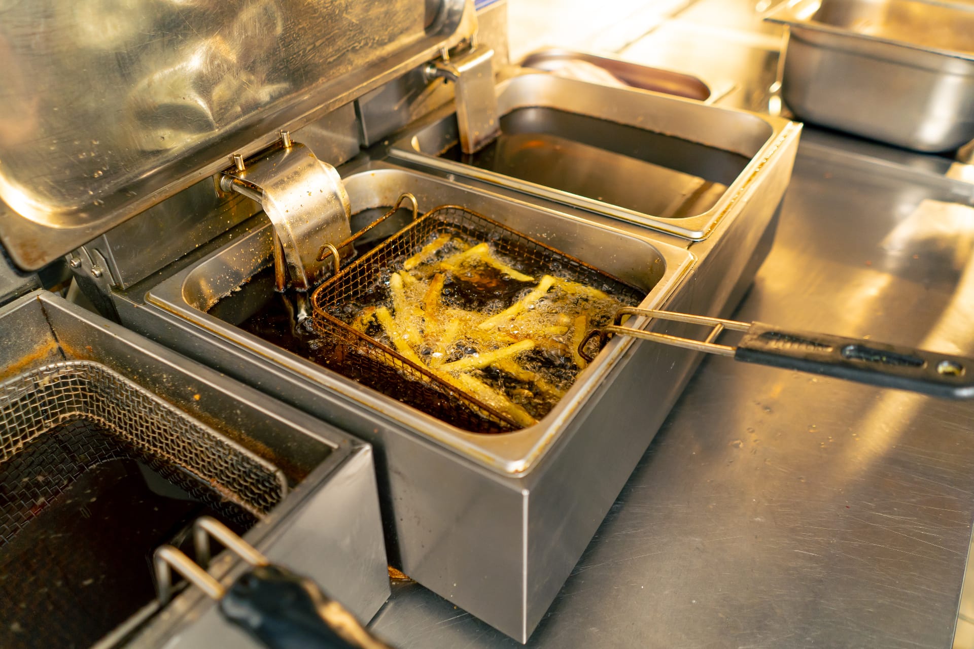 commercial-deep-fryer-used-cooking-oil.jpg French fries cooking in a clean, commercial deep fryer, representing the used cooking oil that Renova recycles for restaurants.